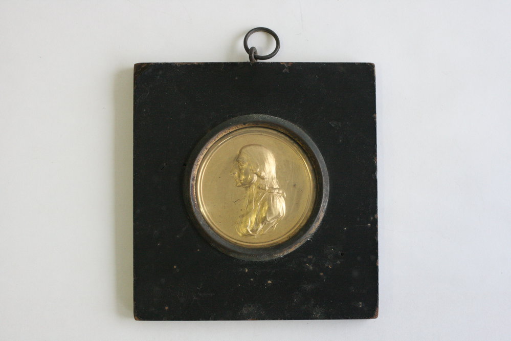 Circular raised gold portrait