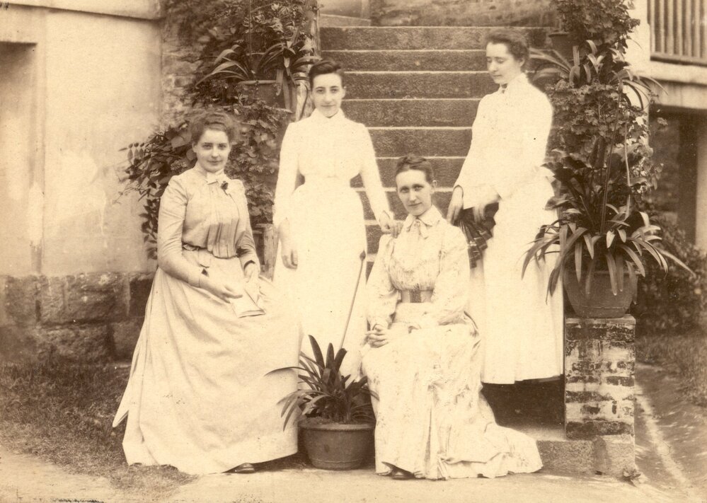 Four European women seated on steps