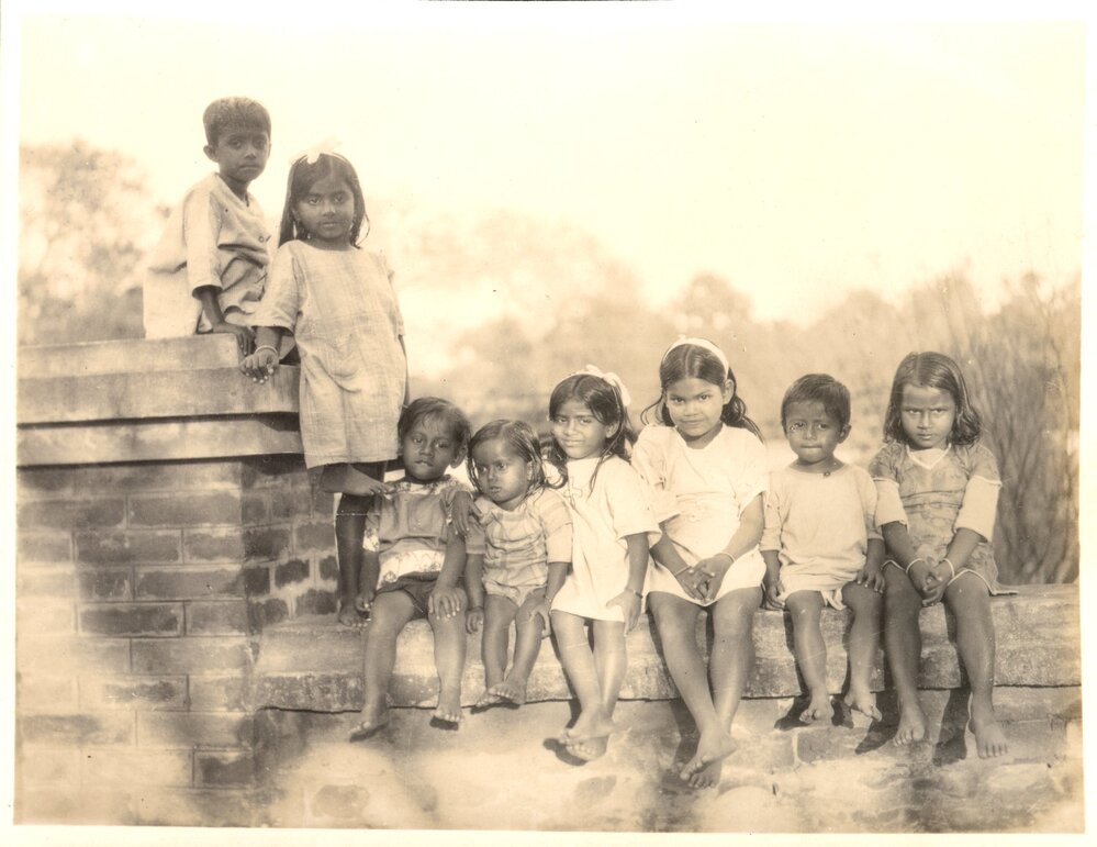 Group of Indian children seated on a wall