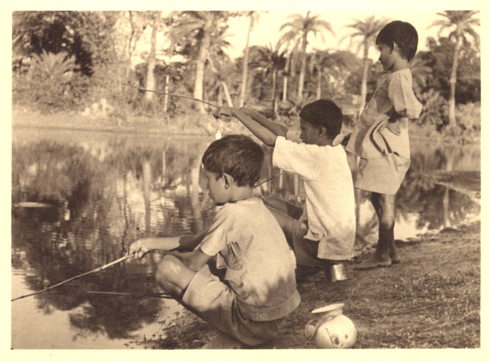Indian boys fishing in a river