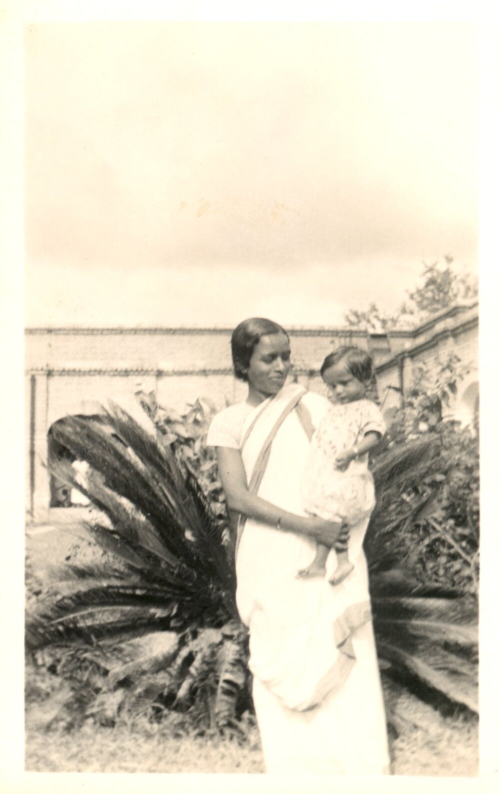 Indian woman holding small child. 