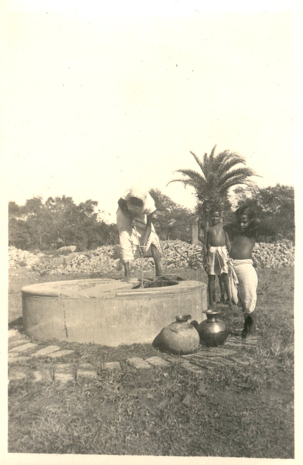 Indian woman and three children at a well