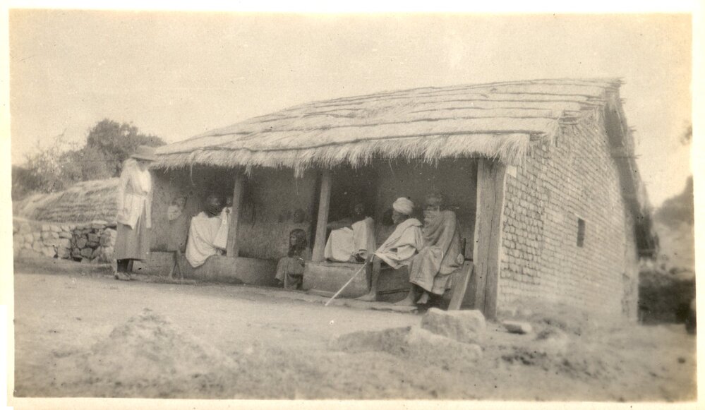 Indian people in a porch of a house. 