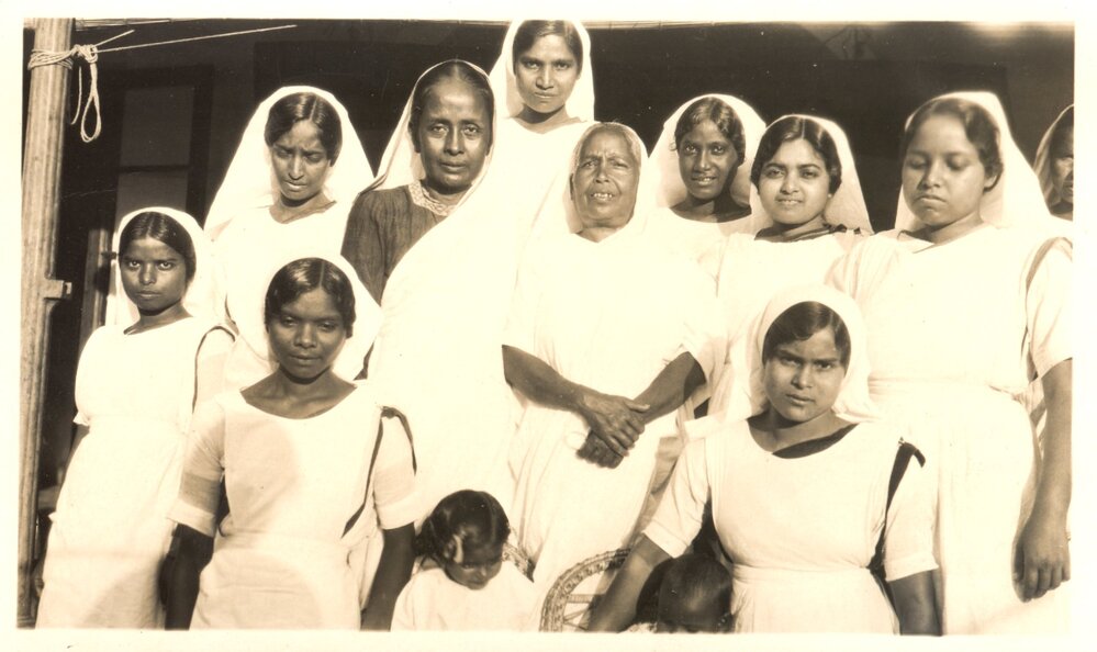 Group photo of 11 women and 2 children. 