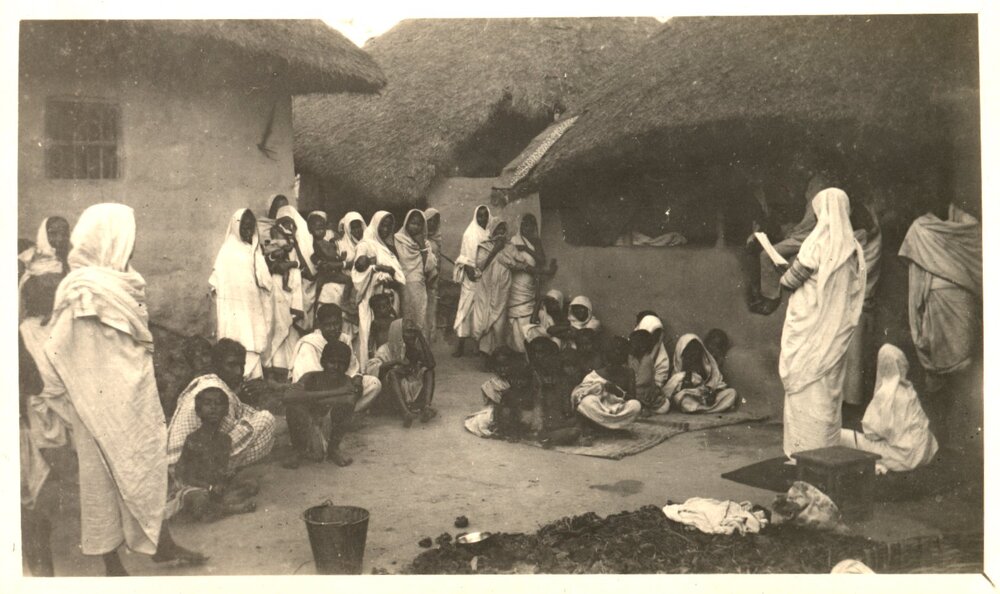 Group of people, listening to a woman. 