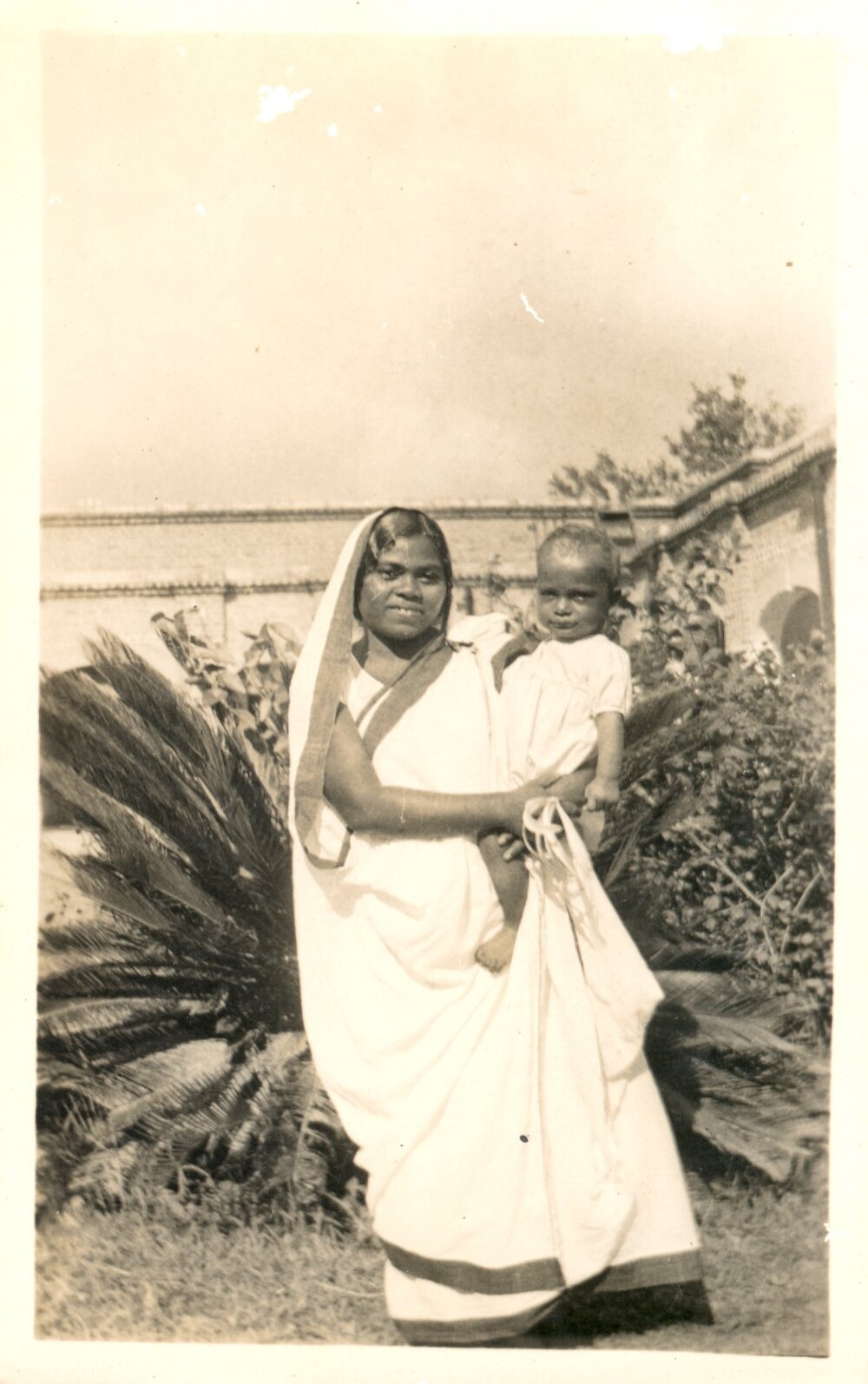 Indian woman holding a small boy. 