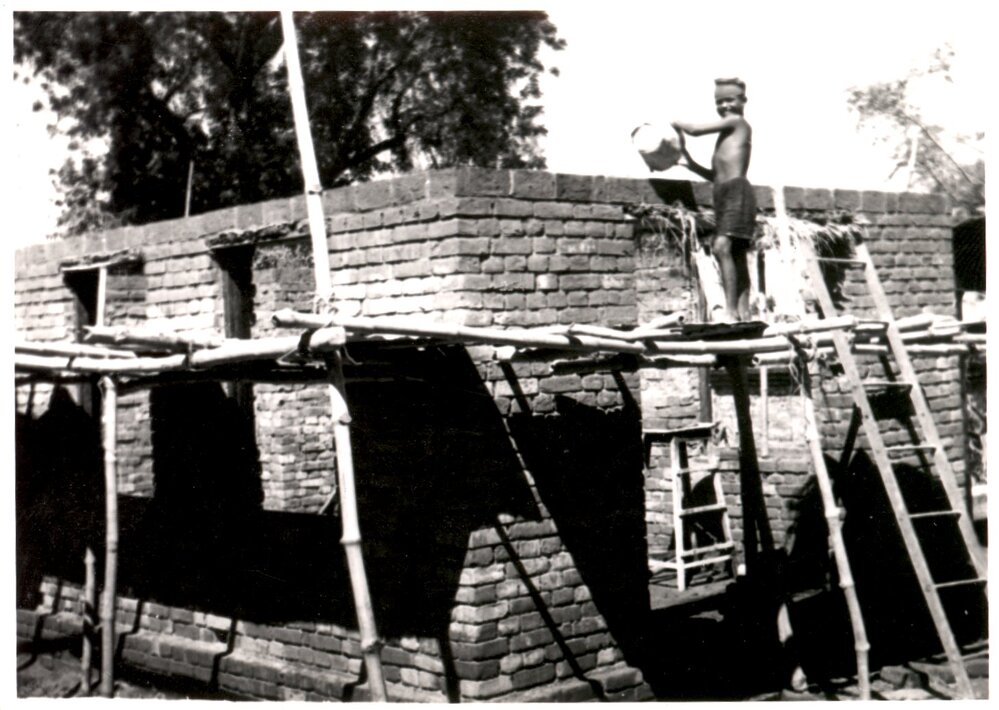 Young boy on wall of new building. 