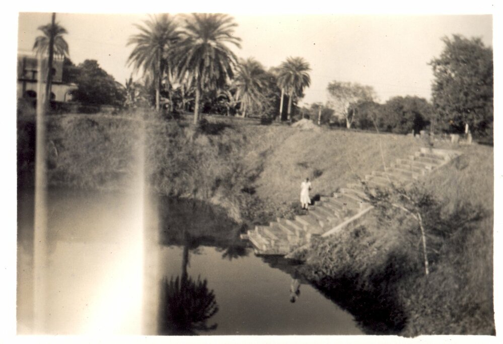 View of lake, bank and building. 
