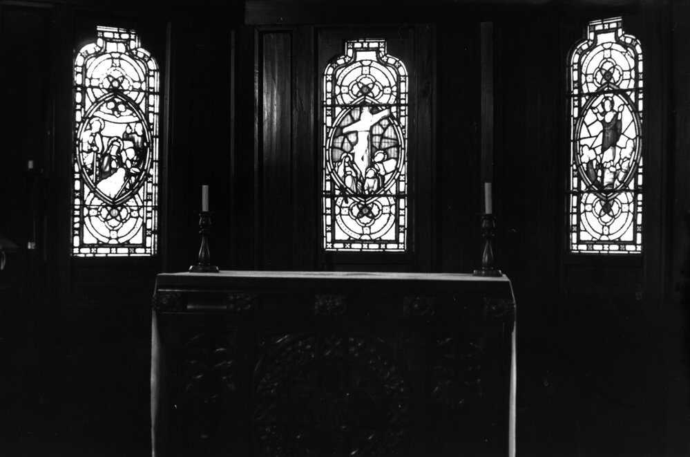 St John's College chapel sanctuary showing the stained glass windows and altar
