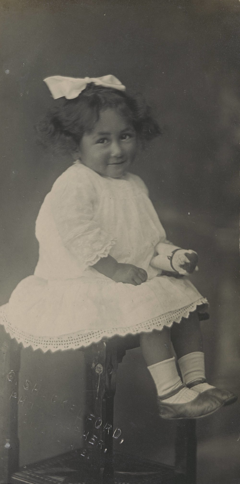 Young child sitting on a tall stool