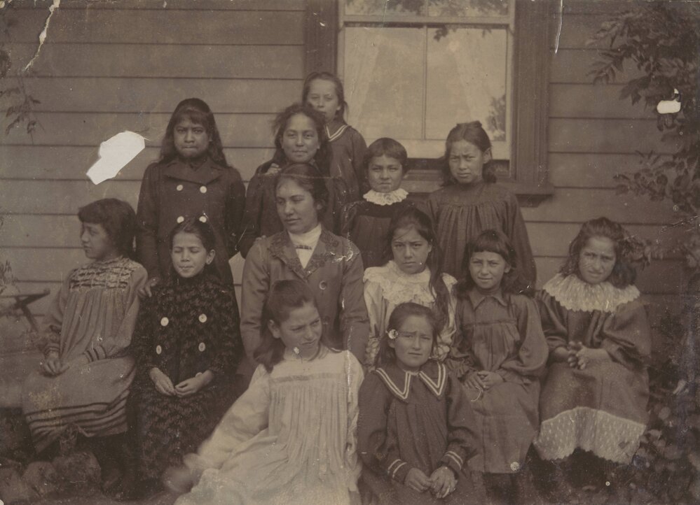 Miss Hall with a group of younger children, labelled 1901 to 1904