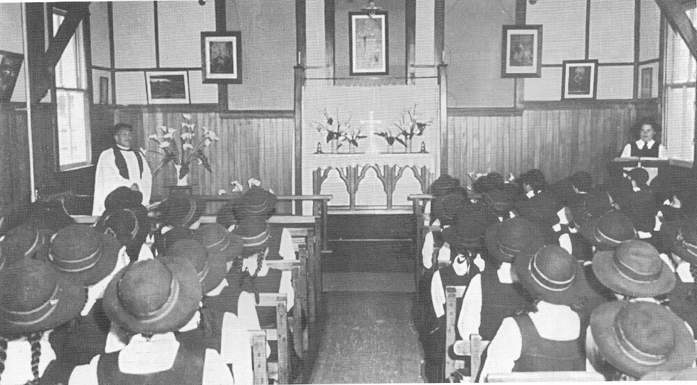 Hukarere students attending a worship service in the old chapel, wearing hats and gym tunics. 