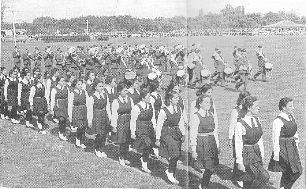 Hukarere students marching with a band and many others on a showground (?)