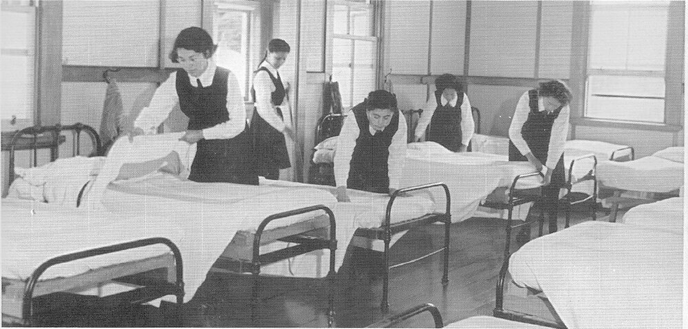 Hukarere students making beds in a dormitory