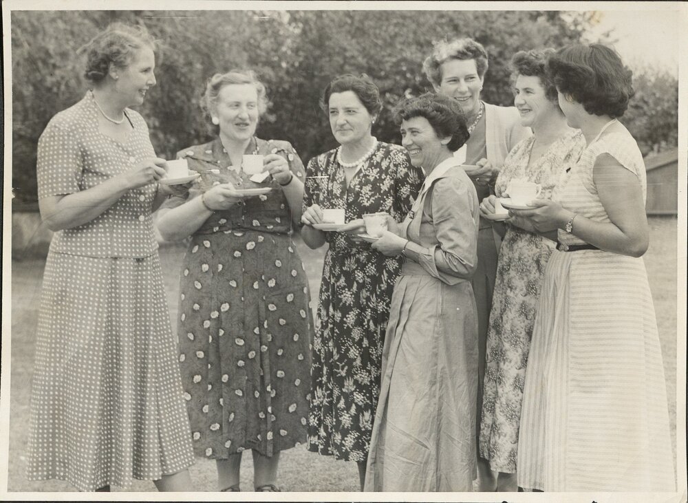 Mother&rsquo;s Union group with tea-cups, caption reads &lsquo;chatting informally&rsquo;