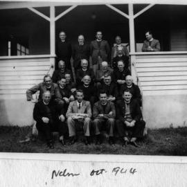 Clergy outside large wooden villa