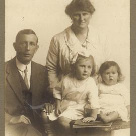 Formal family  portrait of parents with two young children