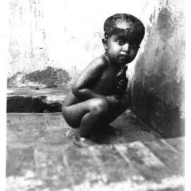 A little Mohammedan boy cooling himself under the tap in the hospital compound