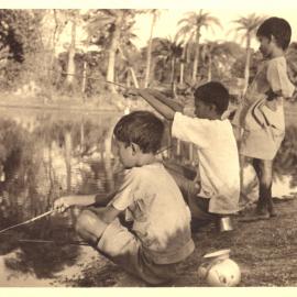 Indian boys fishing in a river