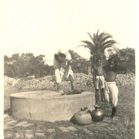 Indian woman and three children at a well