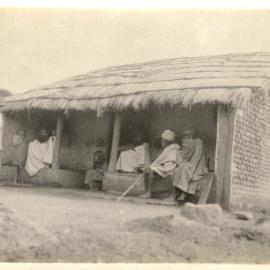 Indian people in a porch of a house. 