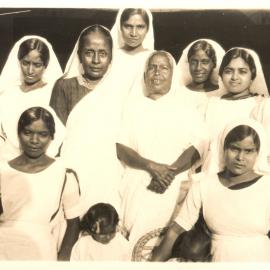 Group photo of 11 women and 2 children. 