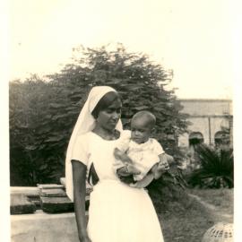 Indian woman holding a small girl. 