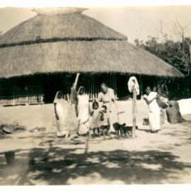 People outside a hut. 