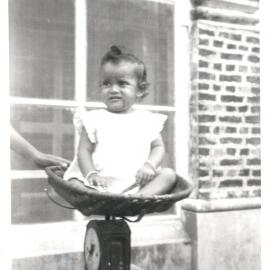 Baby sitting on some scales