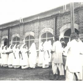 Day of the Blessing. Group of people filing into building. 