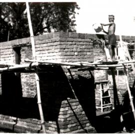 Young boy on wall of new building. 