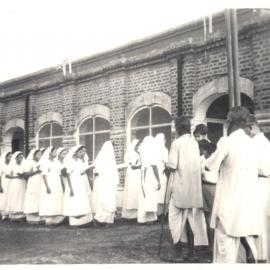 Day of the Blessing. Group of people filing into building. 