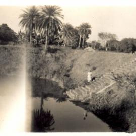 View of lake, bank and building. 