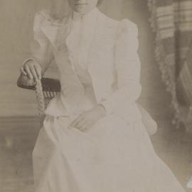 Young woman wearing white dress and jacket