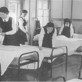 Hukarere students making beds in a dormitory