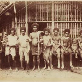 Men holding clubs and curios at Saa